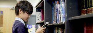 boy looking through books in the library