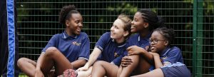 girls leaning against a fence
