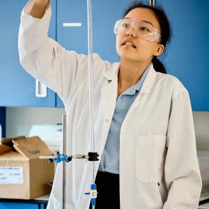 student pouring chemicals through a test tube