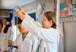 student pouring chemicals through a test tube