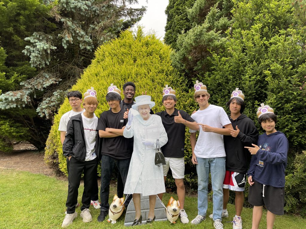 group of teenage boys with cutout of the queen