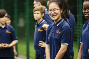 Bishopstrow College students laughing on the sports grounds. 